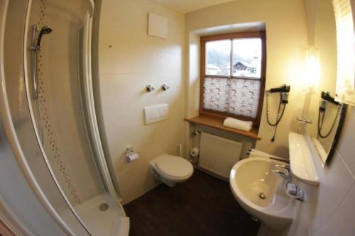 a bathroom with a toilet and a sink and a shower at Gästehaus Angerer in Reit im Winkl