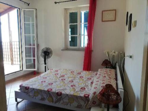 ein Schlafzimmer mit einem Bett in einem Zimmer mit Fenstern in der Unterkunft Ca' Clémentine in Sasso di Bordighera