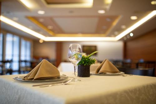 a table with a glass of wine and napkins at Hotel Horizon & Convention Center in Morelia