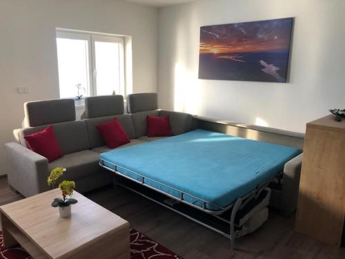 ein Wohnzimmer mit einem Sofa und einem großen Bett in der Unterkunft Papeto in Frymburk