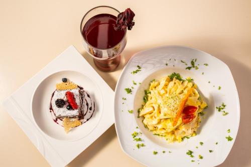 a table with two plates of food and a drink at Hotel Horizon & Convention Center in Morelia