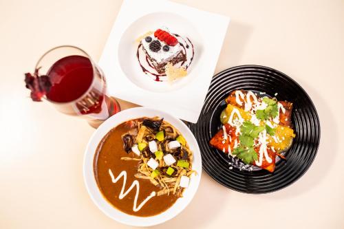 a table with two plates of food and a glass of wine at Hotel Horizon & Convention Center in Morelia