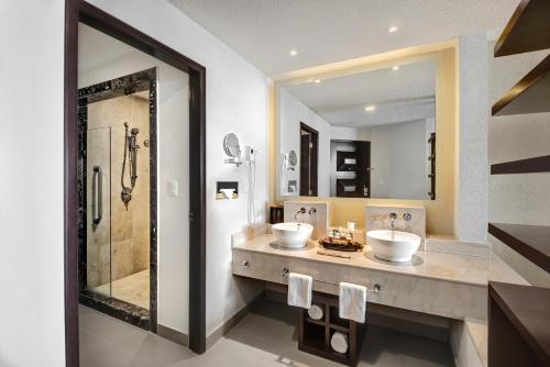 a bathroom with two sinks and a shower at Hotel Marina El Cid Spa & Beach Resort - All Inclusive in Puerto Morelos