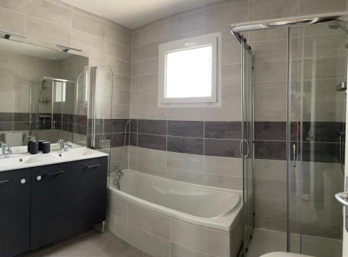 un bagno con vasca, lavandino e doccia di Les Villas de Castel - Villa Les Roses a Castelmaurou
