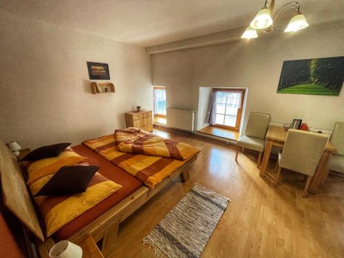 a room with two beds and a dining room with a table at Pension U Kohoutů in Horní Planá