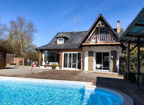 une maison avec une piscine devant une maison dans l'établissement La Belle Rochette, à Bouessay