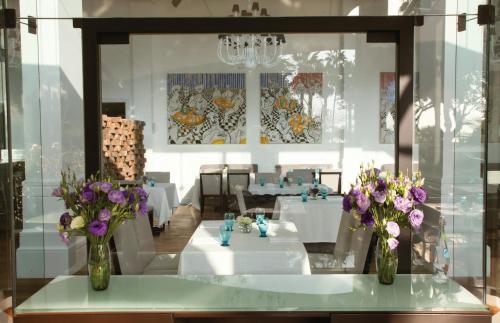 two vases with flowers on a table in a restaurant at Miraflores Park, A Belmond Hotel, Lima in Lima