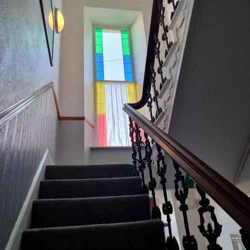 a stairway with a stained glass window at City Inn in St. Davids