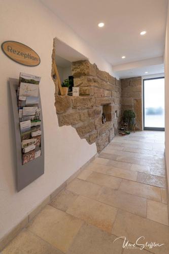 a hallway with a stone wall and a stone floor at Sali Homes - Bergerie in Obersulm
