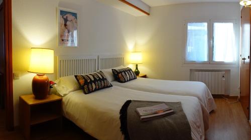 a bedroom with a bed with two lamps and a window at Huegas - A 90 metros del Reloj de Formigal in Formigal