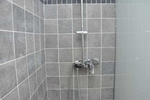 La salle de bains carrelée est pourvue d'une douche avec un tuyau. dans l'établissement Faubourg Saint Martin, à Paris