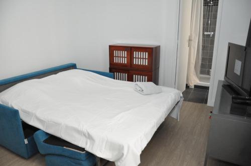 Cette chambre comprend un petit lit et une télévision. dans l'établissement Faubourg Saint Martin, à Paris