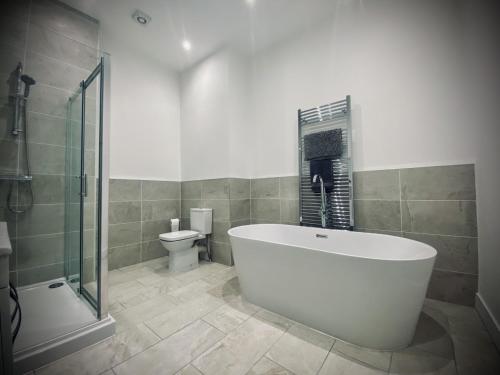 a bathroom with a tub and a shower and a toilet at Seaview Luxury Apartments in Redcar