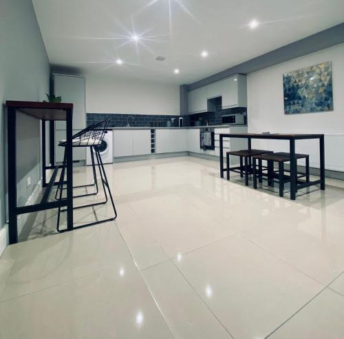 a large kitchen with white tile flooring and black furniture at Seaview Luxury Apartments in Redcar