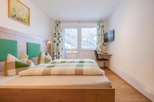 a bedroom with a large bed with a window at Fuchs & Hase in Gasteig