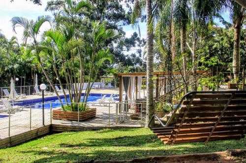 un complejo con piscina y palmeras en Eco Hotel Oceanomare, en Florianópolis