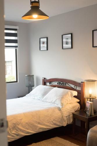 a bedroom with a bed and two lamps and a window at El Caracol in Popayan