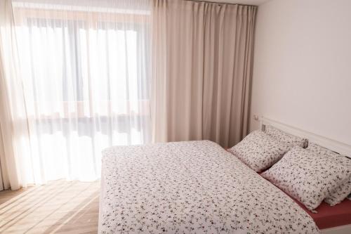 a bedroom with a bed and a large window at AKORD chata in Námestovo