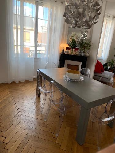 une table à manger et des chaises dans un salon dans l'établissement Appartement de charme 77 m2 proche commodités, à Chamalières
