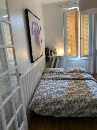 una camera con un letto e due finestre di Appartement de charme 77 m2 proche commodités a Chamalières