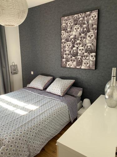 una camera da letto con un letto e un dipinto sul muro di Appartement de charme 77 m2 proche commodités a Chamalières