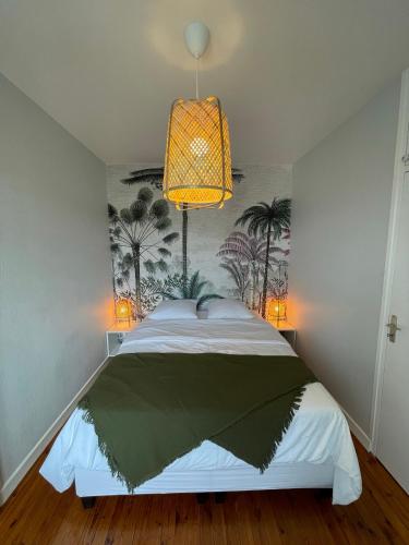 1 dormitorio con 1 cama grande y lámpara de araña en Hyper centre : Appart ancien rénové / tout confort en Clermont-Ferrand