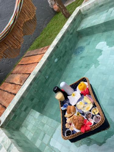 NORI POUSADA في ساو ميغيل دوس ميلاجريس: سلة من الطعام في حمام السباحة