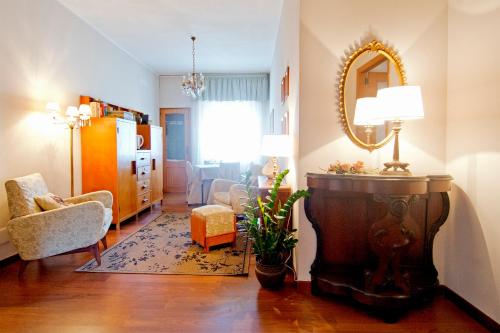 een woonkamer met een stoel en een spiegel bij Mimì Rooms in Cagliari