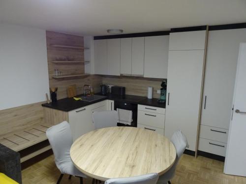 a kitchen with a wooden table and white cabinets at Modern Apartment, Full Kitchen, for 6 in Gmunden