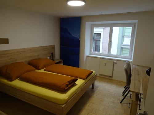 a bedroom with a bed with orange pillows and a window at Modern Apartment, Full Kitchen, for 6 in Gmunden