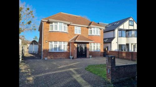 a large brick house with a driveway in front of it at Contractors, Larger Groups, sleeps 14, Iver House, Buckinghamshire, in Buckinghamshire