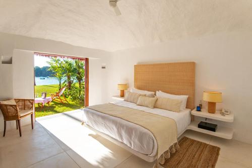 A bed or beds in a room at Bungalows & Casitas de las Flores in Careyes