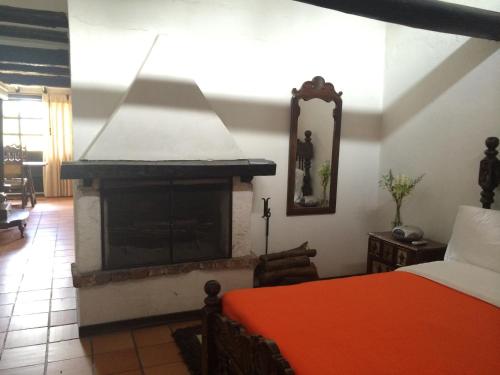 a bedroom with a fireplace and a bed in it at Hotel San Luis de Ucuengá in Nobsa