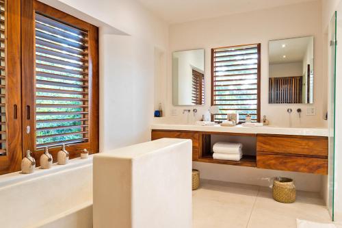 a bathroom with a tub and a sink and a mirror at Bungalows & Casitas de las Flores in Careyes in Careyes