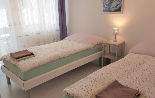 two beds in a bedroom with a lamp on a table at Appartement Lehnbach in Saas-Almagell