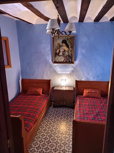 two beds in a room with blue walls at Magnífica casa de pueblo con todas las comodidades in Moratalla
