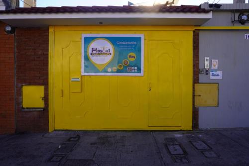 a yellow door on a building with a sign on it at Hostal Guatefriends in Guatemala