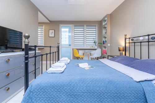 a bedroom with a blue bed with towels on it at Sydonia Apartments - Wyszyńskiego in Szczecin