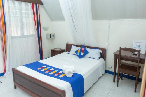 a bedroom with a bed and a desk and a bed at Holidays Hotel in Mahajanga