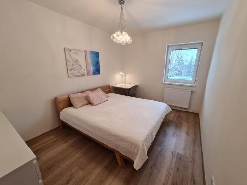 Schlafzimmer mit einem Bett und einem Fenster in der Unterkunft Apartmán Útulnô: Relax, sauna a výberová káva in Horní Maršov