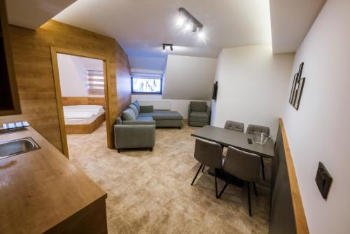 una pequeña sala de estar con sofá y mesa. en Apartments Suncani Vrhovi Kopaonik, en Kopaonik