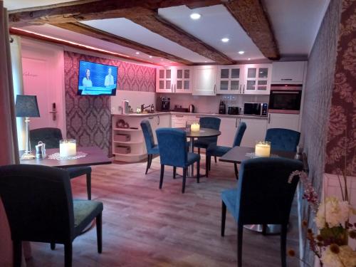 a dining room with tables and chairs and a kitchen at AnaCapri Gästehaus Le Havre in Ueckermünde