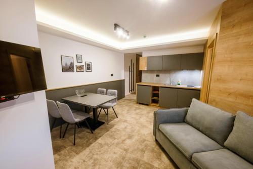 - un salon avec un canapé et une table dans l'établissement Apartments Suncani Vrhovi Kopaonik, à Kopaonik