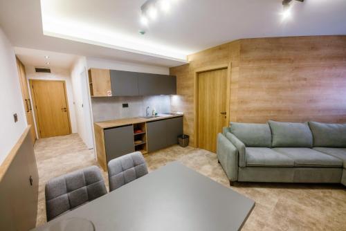 a living room with a couch and a kitchen at Apartments Suncani Vrhovi Kopaonik in Kopaonik