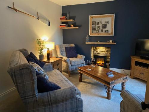 a living room with two couches and a fireplace at Monawilline Cottage in Lamlash