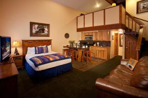 a bedroom with a bed and a living room and a kitchen at Cottam's Lodge by Alpine Village Suites in Taos Ski Valley