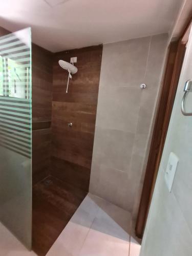 a shower with a glass door in a bathroom at Pousada Res. Belmont in Pirangi do Norte