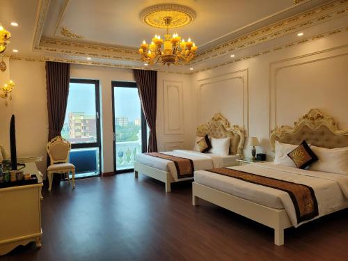 a large bedroom with two beds and a chandelier at Hoa Đông Aureum Hotel Hà Nam in Châu Cầu