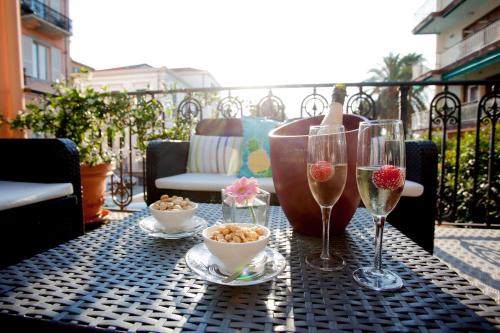 a table with glasses of wine and bowls of food at Albergo Belsoggiorno in Sanremo