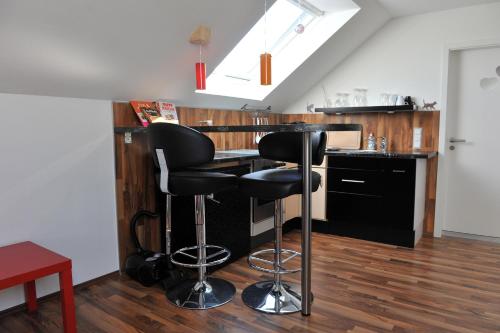 a kitchen with two bar stools and a counter at Ferienwohnung Bergisch Land in Wermelskirchen